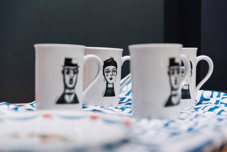 four cups with face drawings on them. 