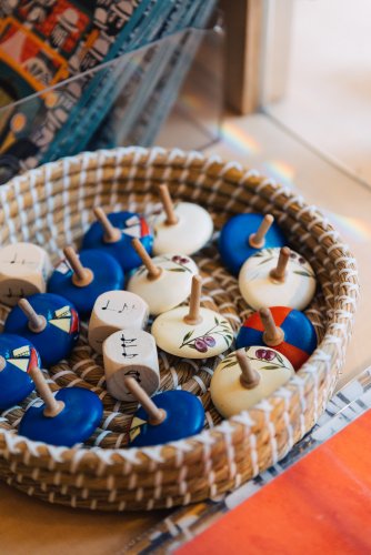 wooden spinning tops and dice in basket.