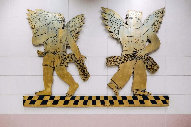 an art installation of two bronze male angels.