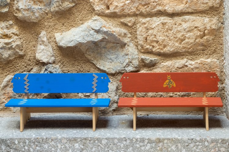 Two miniature benches, a red and a blue one.