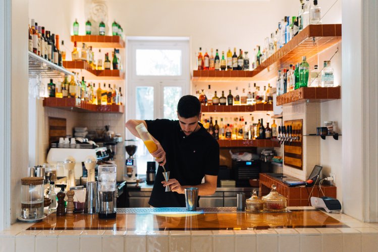 a bartender serving a cocktail.