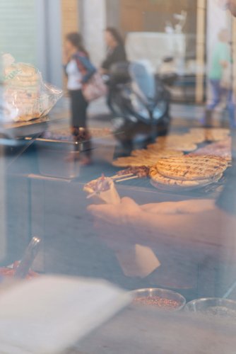 a man wrapping a pita inside of a window.