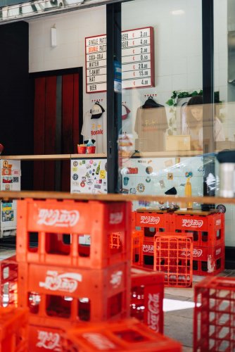 Coca-Cola bottle crates turned to stools, a menu on the wall behind.