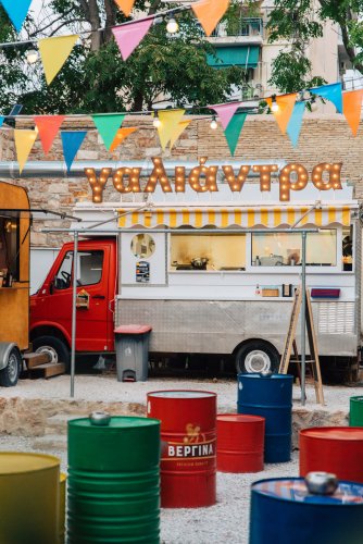 barrels, foodtrucks, flags in a yard and a sign that reads "galiantra"