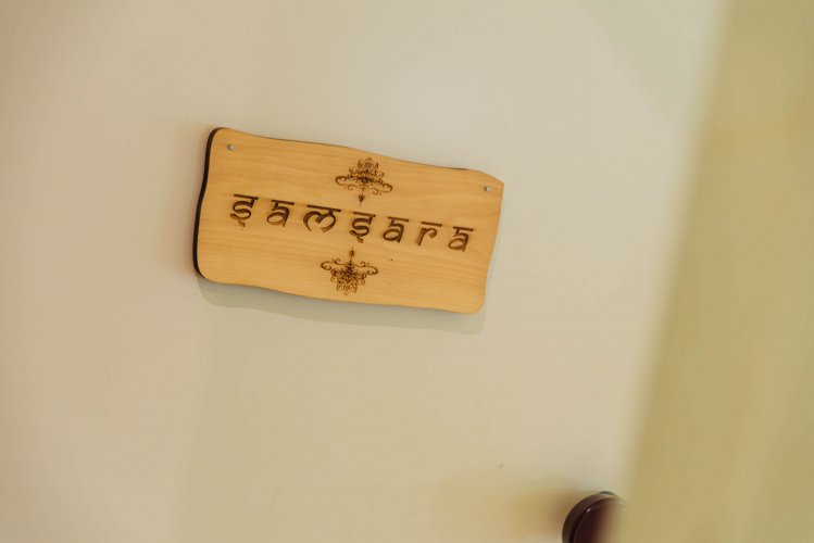 a wooden sign on the wall that reads "samsara"