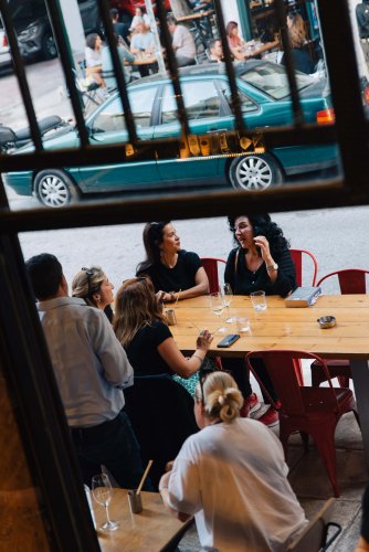 people sitting on a wooden table at a cafe