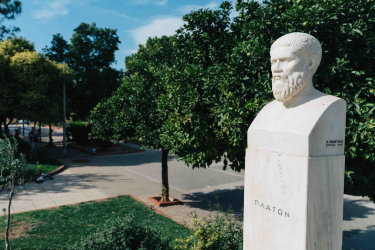 bust of a man in a park, trees around.