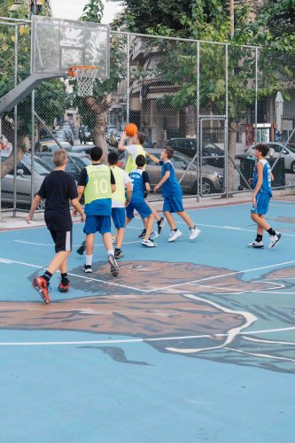 kids playing basketball at an outdoor court.