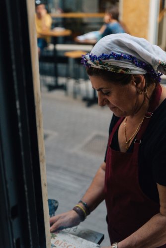 a middle-aged woman wearing a head scarf for cooking