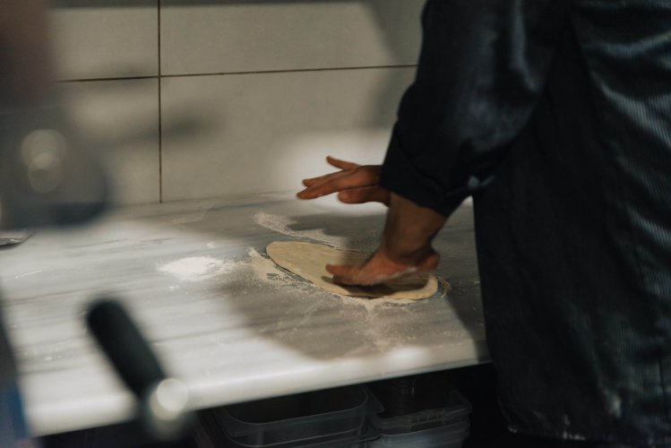 a man in a kitchen working on dough