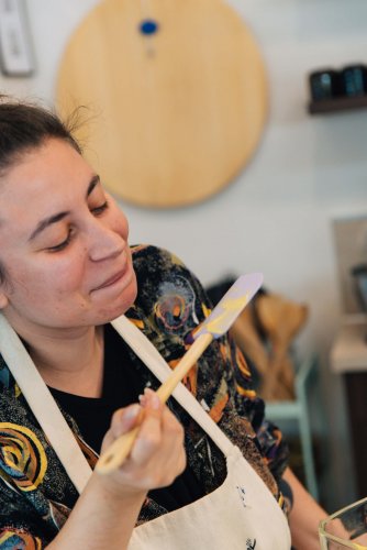 a woman licking bechamel from a mariz spatula.