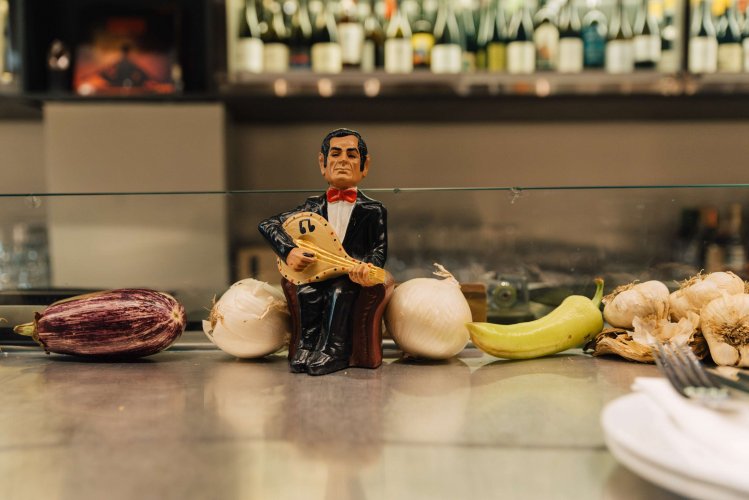 a miniature of a musician among vegetables on a counter.
