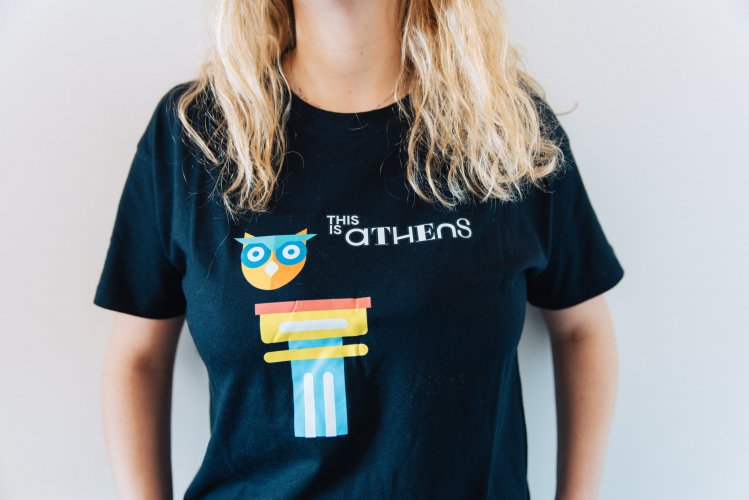 a picture of a woman, wearing a black t-shirt that reads this is athens and has illustrations of an ancient column and an owl