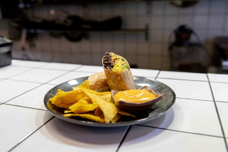 a dish with a burrito and nuchos at a kitchen counter