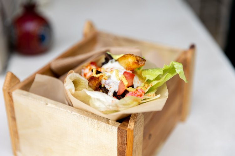a souvlaki in a wooden box on a table.