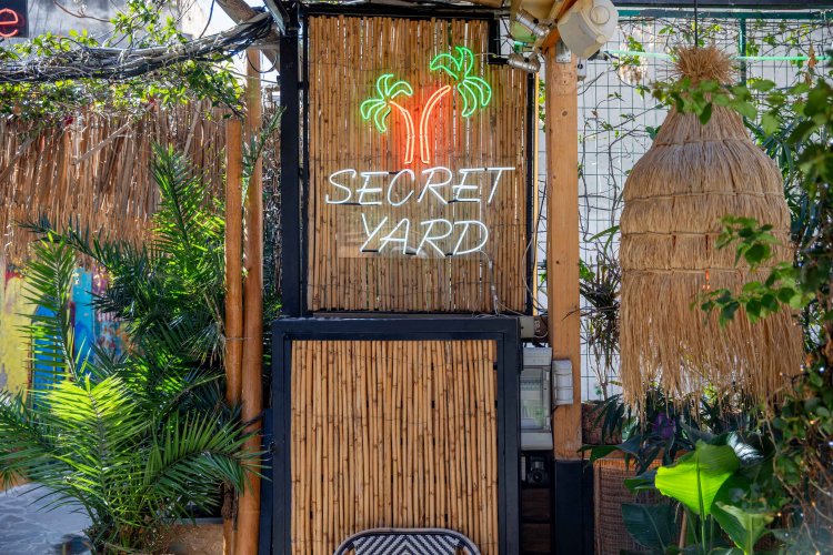 a sign among plants that reads "secret yard"