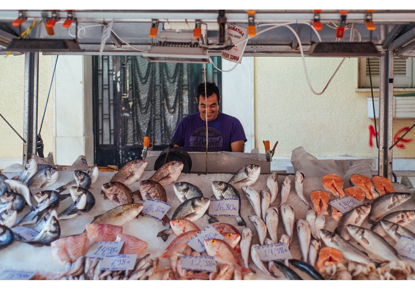 a man selling fish on a counter.