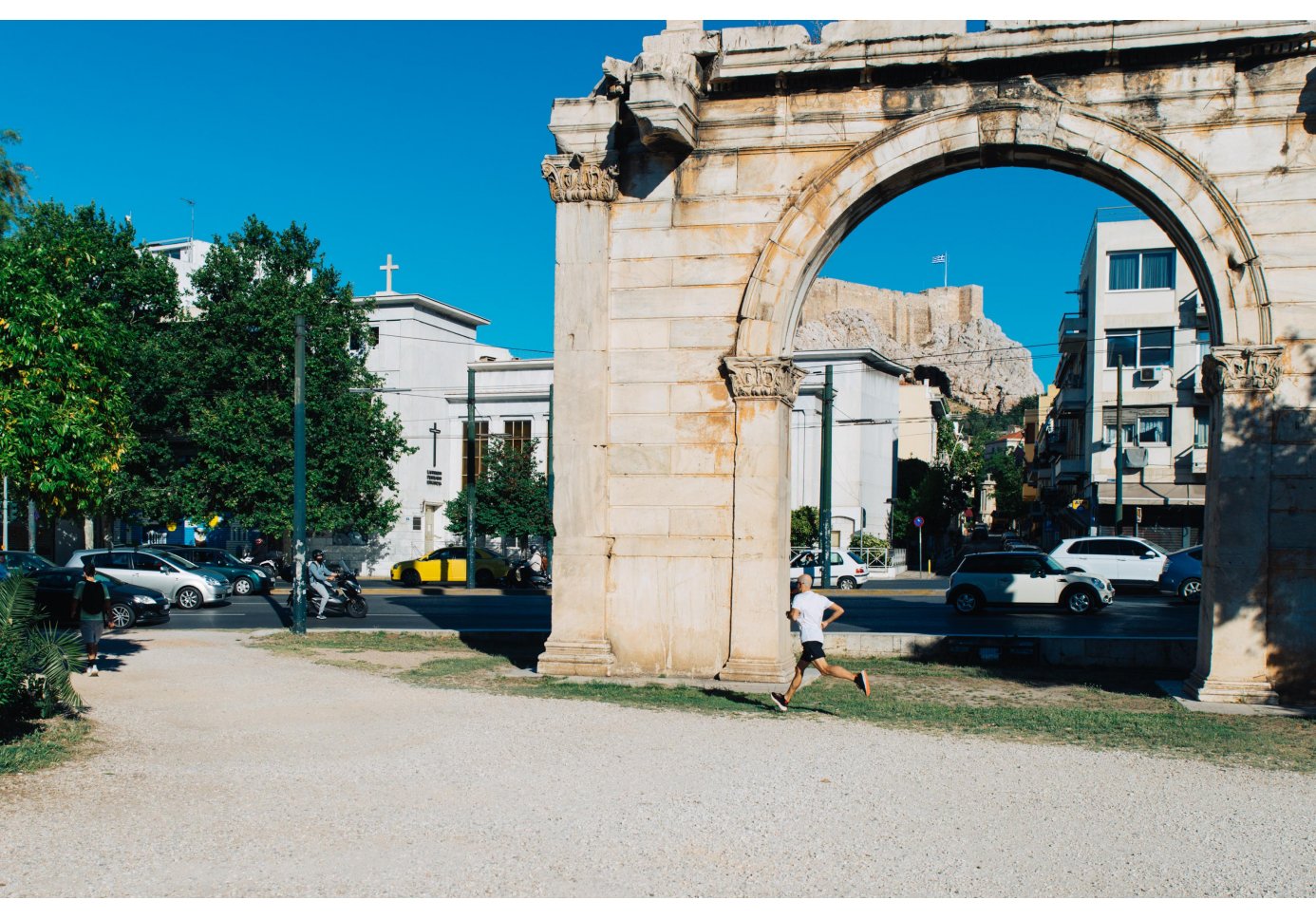 A man running in Athens beneath Adrian's Arch