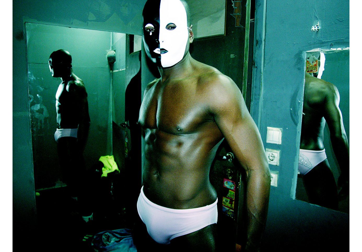 A black man wearing white underwear and a black and white face mask
