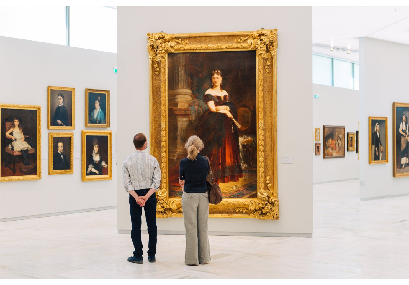 A man and a woman looking at a the painting "Portrait of Mrs Serpieri" in the National Gallery of Greece in Athens