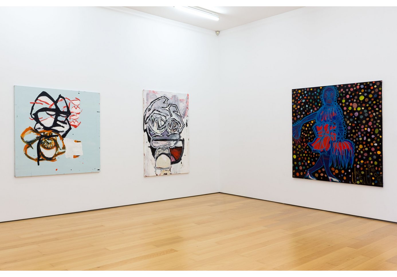 three large paintings hanging on two white walls.