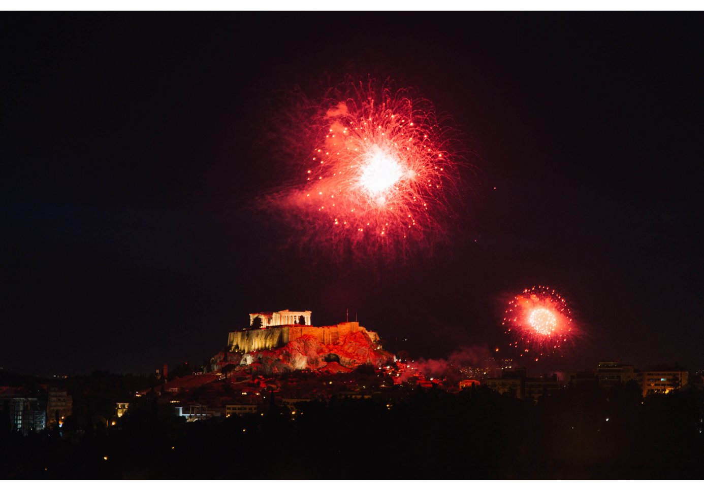 red fireworks at the night sky above the Acropolis.