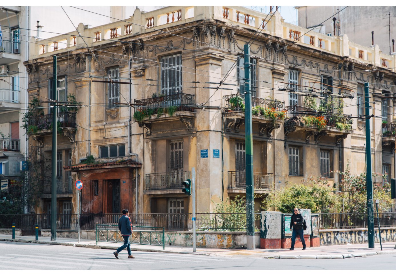 a corner two-storey building, people walking down the street. 