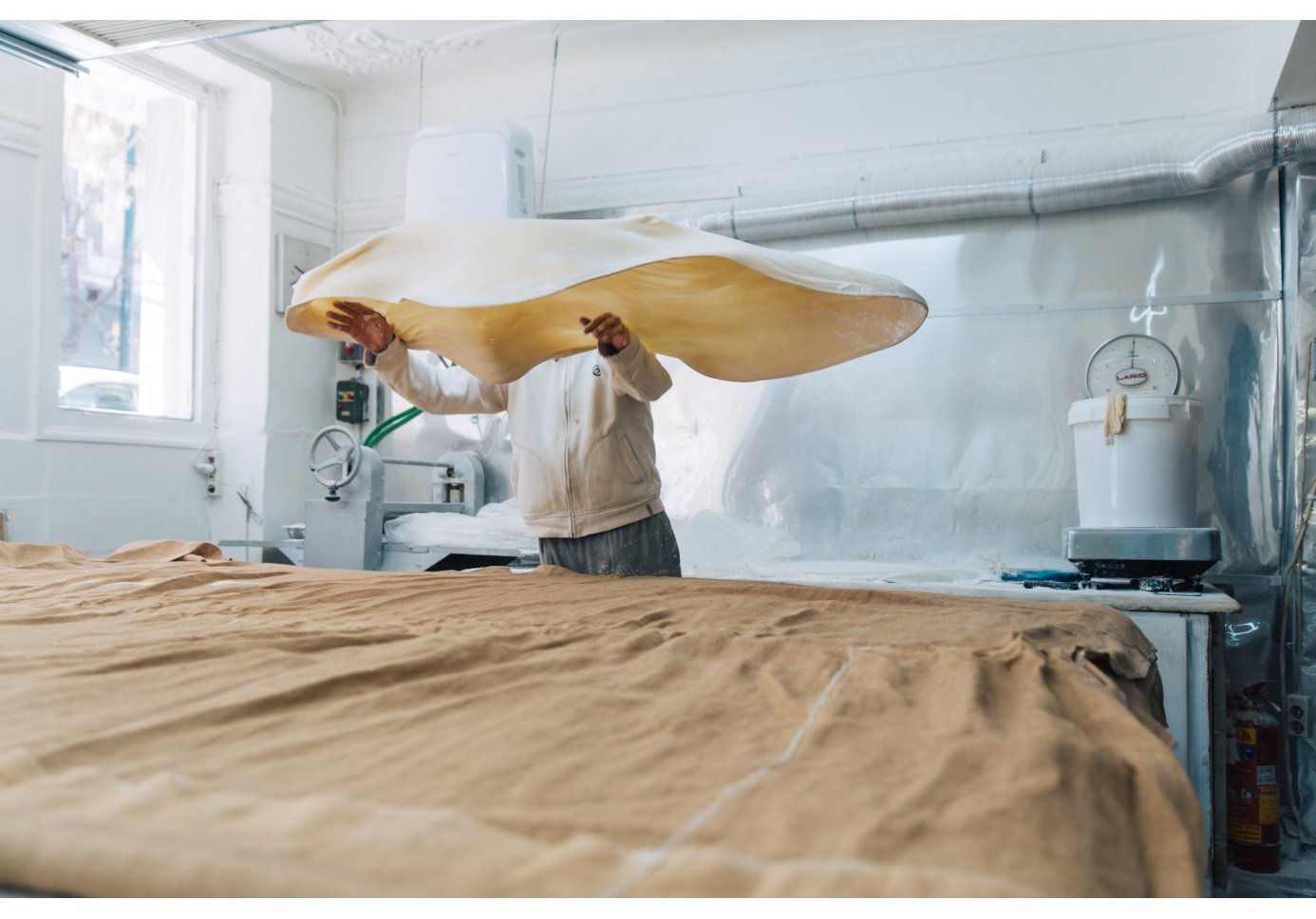 a man tossing the dough in the kitchen. 