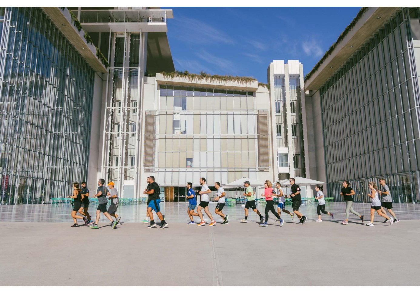 people running in front of a contemporary structure