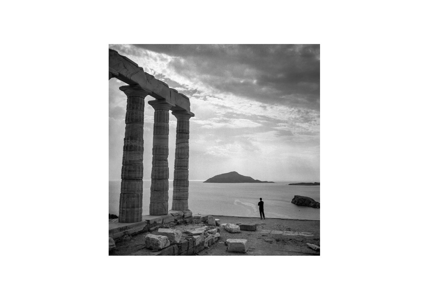 A man stand looking out to sea at the Temple of Poseidon at Sounion. Photo by Robert McCabe. 