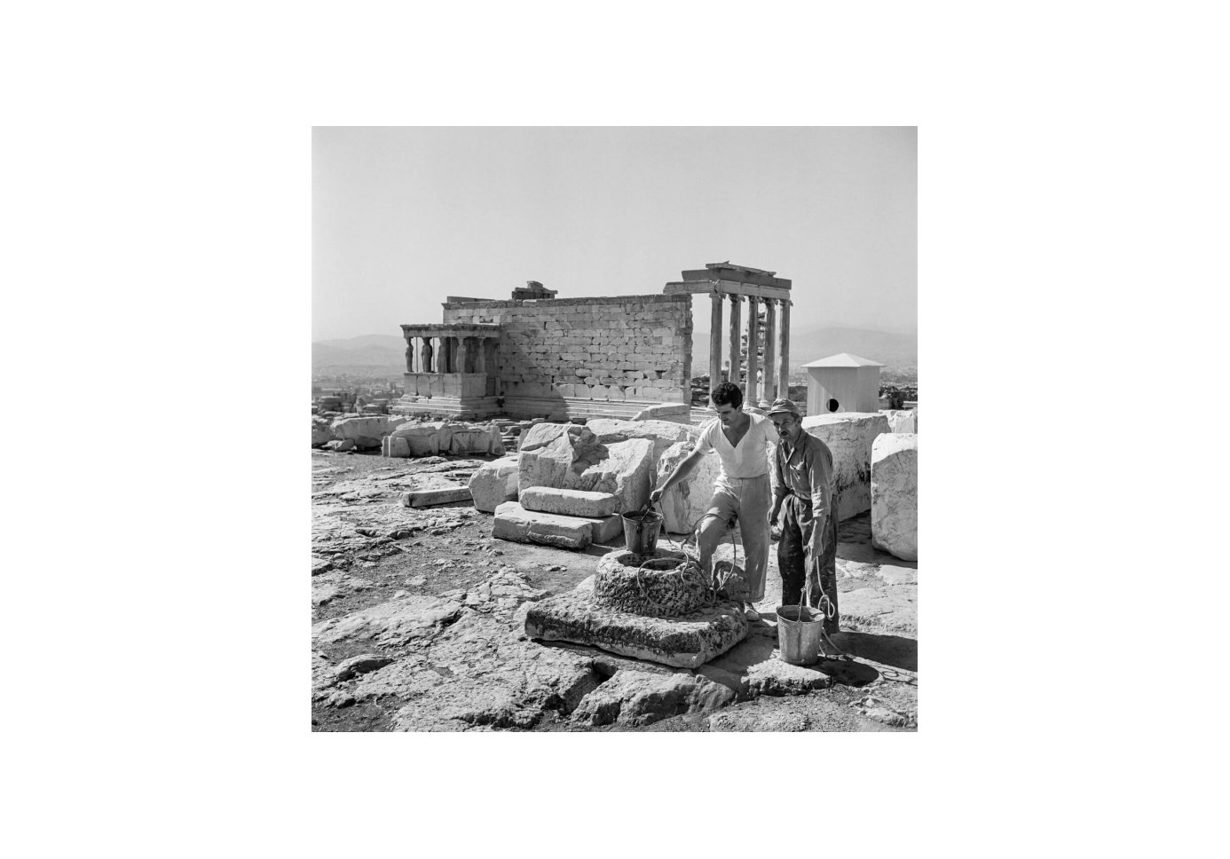 Two men drawing water from a cistern at the Acropolis. Photo by Robert McCabe.